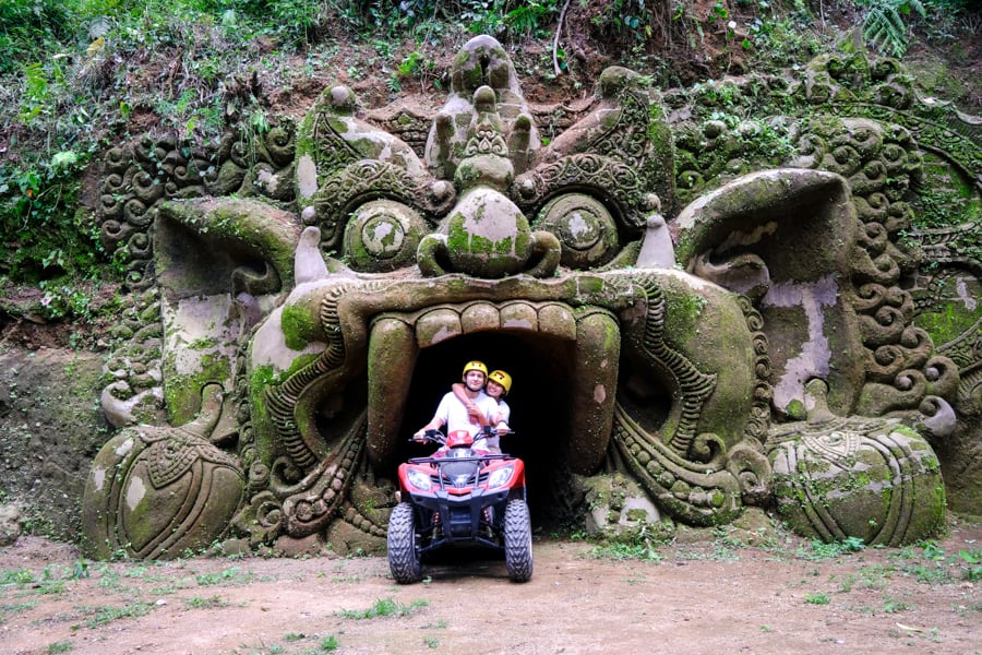 Couple riding an ATV at a barong demon cave in Ubud
