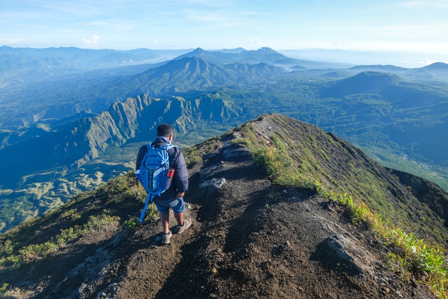 Climbing Mount Inerie Volcano In Flores, Indonesia Trekking guide walking down from the summit of Mount Inerie