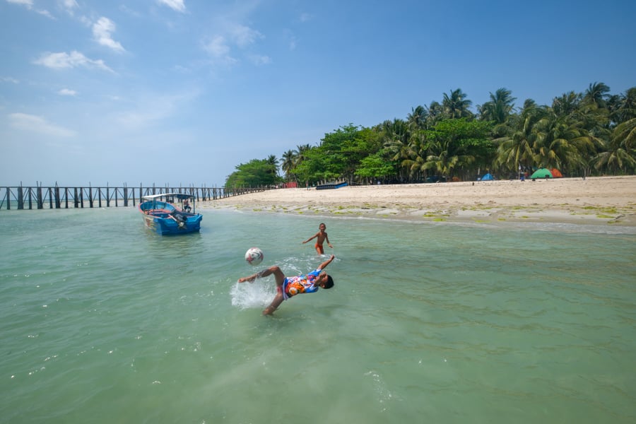 Local kids playing soccer in the ocean at Ketawai island