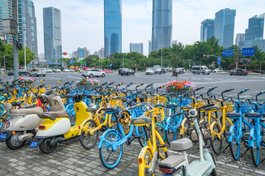 Row of yellow and blue bicycles parked in the city