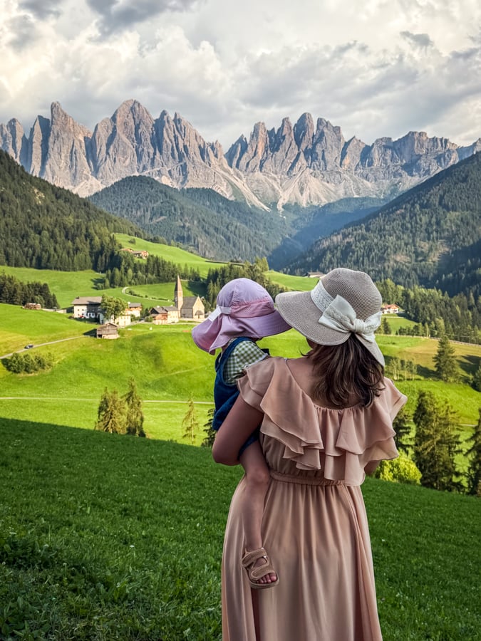 Mom and baby standing at the Santa Maddalena viewpoint in Italy